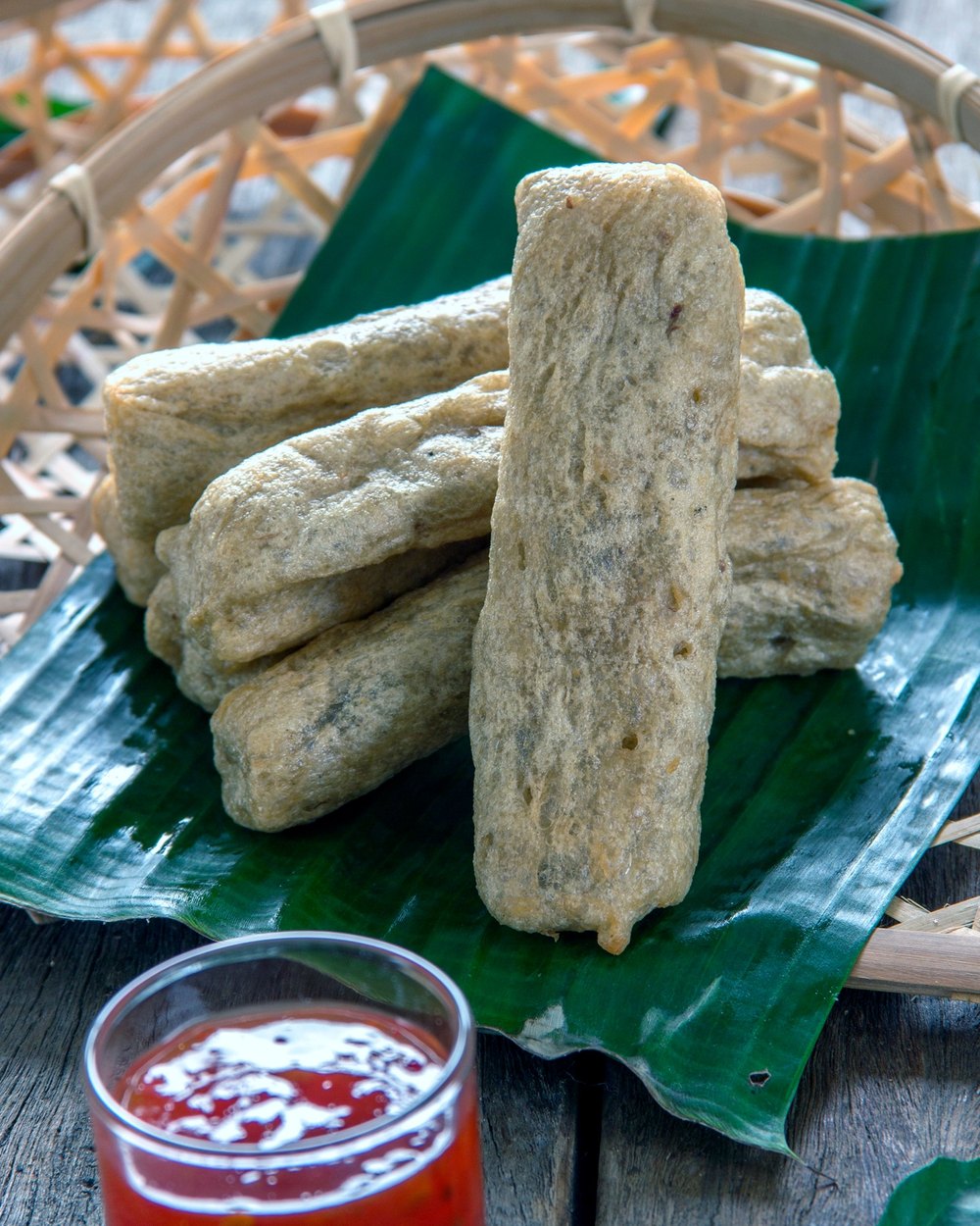 Keropok Lekor in a woven basket with chilli sauce